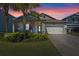 Charming single-Gathering home with well-manicured lawn, lovely landscaping and a welcoming covered porch at sunset at 3456 Shallow Cove Ln, Clermont, FL 34711