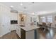 Bright kitchen featuring an island with sink, gray countertops, and wood-look floors leading to a dining area at 3456 Shallow Cove Ln, Clermont, FL 34711