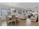 Open-concept living and dining area with modern furnishings, wood-look floors, and abundant natural light at 3456 Shallow Cove Ln, Clermont, FL 34711