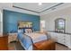 Comfortable main bedroom with blue accents, stylish furnishings, and an en-suite bathroom offers a relaxing retreat at 3456 Shallow Cove Ln, Clermont, FL 34711