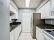 Galley kitchen featuring white cabinetry, dark granite counters, and stainless appliances at 3700 Idlebrook Cir # 114, Casselberry, FL 32707