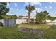 Fenced backyard with a shed, grassy lawn, and landscaped area, offering privacy and storage at 3994 Irma Shores Dr, Orlando, FL 32817