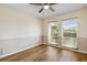 Cozy bedroom showcasing two-tone walls, wood-look flooring, and natural light from two windows at 3994 Irma Shores Dr, Orlando, FL 32817