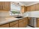 Kitchen displaying wood cabinets, beige countertops, stainless steel dishwasher and a black sink at 3994 Irma Shores Dr, Orlando, FL 32817