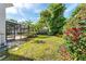 Spacious backyard featuring green grass, mature landscaping, and screened-in pool area at 418 Curry Ct, Altamonte Springs, FL 32714