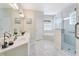 Bright bathroom featuring double sinks, vanity, and a glass-enclosed shower adjacent to the soaking tub at 418 Curry Ct, Altamonte Springs, FL 32714