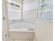 Bright bathroom corner features a luxurious soaking tub with marble tile and a window for natural light at 418 Curry Ct, Altamonte Springs, FL 32714