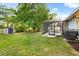 Spacious backyard with a screened lanai, lush lawn, mature trees, and a storage shed at 4246 Clarinda St, Orlando, FL 32811