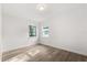 Cozy bedroom featuring wood-look floors and natural light from two windows at 4246 Clarinda St, Orlando, FL 32811