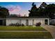 Charming home featuring arched entryways, well-maintained lawn, and mature landscaping at 4246 Clarinda St, Orlando, FL 32811