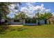 Exterior view of the home's rear, featuring a combination patio, grassy area, and functional sheds at 4415 Gilpin Way, Orlando, FL 32812