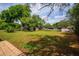 Large backyard featuring well-maintained grass, mature trees, and shed storage at 4415 Gilpin Way, Orlando, FL 32812