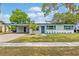 Charming single-story home featuring a well-manicured lawn and blue accent details at 4415 Gilpin Way, Orlando, FL 32812