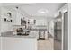 Modern kitchen with white cabinetry, stainless steel appliances, and a breakfast bar at 4415 Gilpin Way, Orlando, FL 32812