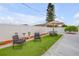 Backyard featuring green artificial turf, landscaping, and patio furniture with an umbrella at 4443 Doris Dr, New Smyrna Beach, FL 32169