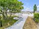 Charming home exterior with a spacious driveway, manicured lawn, and mature trees at 4443 Doris Dr, New Smyrna Beach, FL 32169