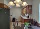 Kitchen area with stainless steel refrigerator, wood cabinets, glass table, and decorative hanging lights at 509 Dorothy Cir, Eustis, FL 32726