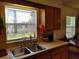 Kitchen sink area with window offering backyard views, ample counter space, and wooden cabinets at 509 Dorothy Cir, Eustis, FL 32726