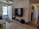 Open living area with front door entry, featuring tile floors and a large television at 509 Dorothy Cir, Eustis, FL 32726