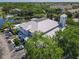 Stunning aerial view of building with clock tower, pond, and mature trees at 5144 City St # 211, Orlando, FL 32839