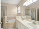Bathroom features dual sinks, soaking tub, and separate glass-enclosed shower at 558 Knollwood Dr, Davenport, FL 33837