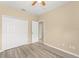A simple bedroom featuring wood-look flooring, a ceiling fan, and double closet doors at 558 Knollwood Dr, Davenport, FL 33837