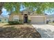 Charming single-story home featuring a two-car garage and a well-maintained front yard with mature trees at 558 Knollwood Dr, Davenport, FL 33837