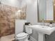 Bathroom with a stone shower featuring glass doors, a toilet, and a pedestal sink with an elegant mirror at 6313 Bordeaux Cir, Sanford, FL 32771