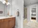 Bright bathroom with a vanity, large mirror, and shower-tub combo featuring glass doors at 6313 Bordeaux Cir, Sanford, FL 32771