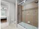 Bathroom featuring a shower-tub combo with tan tiling and glass sliding doors at 6313 Bordeaux Cir, Sanford, FL 32771