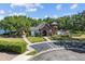 Beautiful brick clubhouse with pool and lake view nestled among mature trees on a sunny day at 6313 Bordeaux Cir, Sanford, FL 32771
