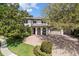 Beautiful two-story home with a brick driveway, three-car garage, and covered front porch, surrounded by trees and green lawn at 6313 Bordeaux Cir, Sanford, FL 32771
