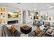 Spacious open-concept living room features a modern fireplace, a large TV, and an adjacent white gourmet kitchen at 6313 Bordeaux Cir, Sanford, FL 32771