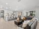 Spacious living room featuring a comfortable leather sectional sofa and gourmet kitchen at 6313 Bordeaux Cir, Sanford, FL 32771