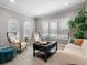 Bright living room featuring hardwood floors, large windows, neutral furniture, and a decorative accent plant at 6313 Bordeaux Cir, Sanford, FL 32771