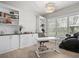 Bright office space with built-in shelving, large windows, and a modern chandelier, perfect for a productive work environment at 6313 Bordeaux Cir, Sanford, FL 32771