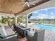 Relaxing outdoor area with wicker furniture, a gas fire pit, and a view of the pool and waterfront at 6313 Bordeaux Cir, Sanford, FL 32771