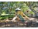 Community playground with slides and climbing area, shaded by mature trees at 6313 Bordeaux Cir, Sanford, FL 32771