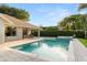 Backyard pool and spa surrounded by a brick patio, lush landscaping, and a covered sitting area perfect for entertaining at 652 Rochester St, Oviedo, FL 32765
