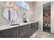 Modern bathroom featuring a double vanity with granite countertops and designer mirrors at 748 Desert Mountain Ct, Reunion, FL 34747
