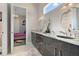 Elegant bathroom featuring double sinks, decorative mirrors, and a doorway into a bedroom at 748 Desert Mountain Ct, Reunion, FL 34747