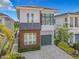 Contemporary two-story home featuring a gray garage door, modern windows and manicured landscaping at 748 Desert Mountain Ct, Reunion, FL 34747