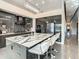 Modern kitchen island has white leather bar stools and features a marble countertop with a drop-down chandelier at 748 Desert Mountain Ct, Reunion, FL 34747