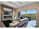 Bright living room with fireplace, modern furniture, and expansive windows overlooking the outdoor pool area at 748 Desert Mountain Ct, Reunion, FL 34747