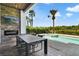 Beautiful outdoor dining area with built-in grill, pool view, and outdoor television at 748 Desert Mountain Ct, Reunion, FL 34747