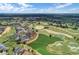 An aerial view showcases a lush golf course community with ponds and luxury homes lining the green at 7652 Whisper Way # 301, Reunion, FL 34747