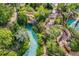 Aerial view of a lush waterpark, showcasing a lazy river with waterfalls and stone staircases at 7652 Whisper Way # 301, Reunion, FL 34747