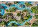 Aerial view of a resort featuring a lazy river, pools, and lounge areas with tropical landscaping at 7652 Whisper Way # 301, Reunion, FL 34747