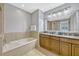 Bathroom featuring a tub, granite counters with double sinks, and tiled floors at 7652 Whisper Way # 301, Reunion, FL 34747