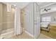 Bathroom with tub and shower showcasing access to bedroom with comfortable bed at 7652 Whisper Way # 301, Reunion, FL 34747